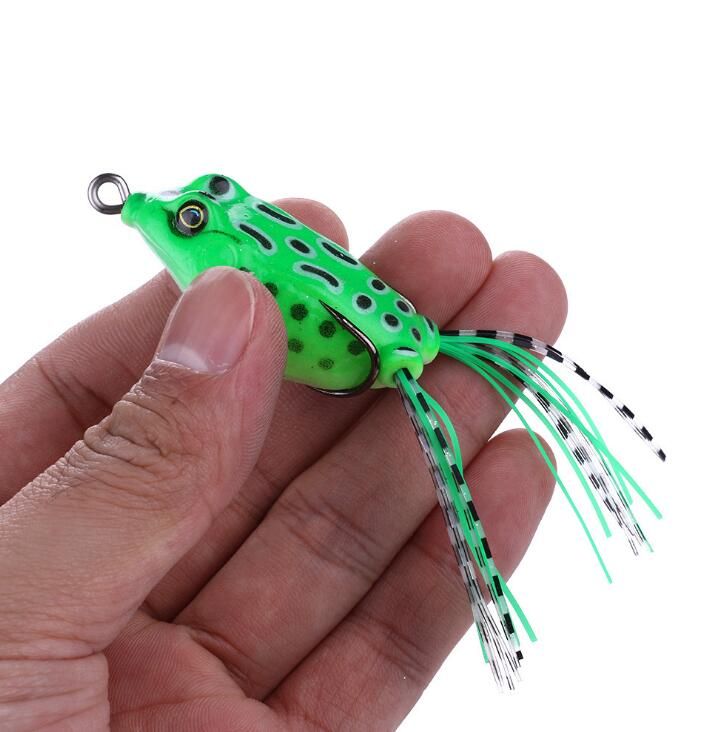 A green frog lure held in a hand to show its size