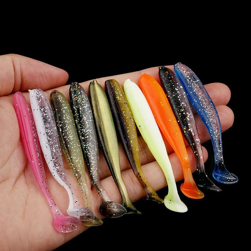 A handful of two-tone soft lures held in a hand